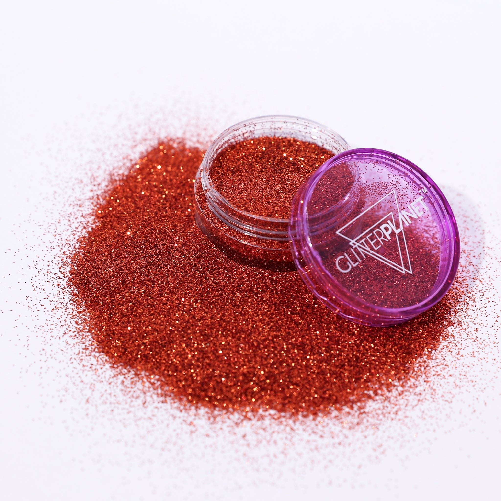copper glitter in a small open container with a purple lid on a white background