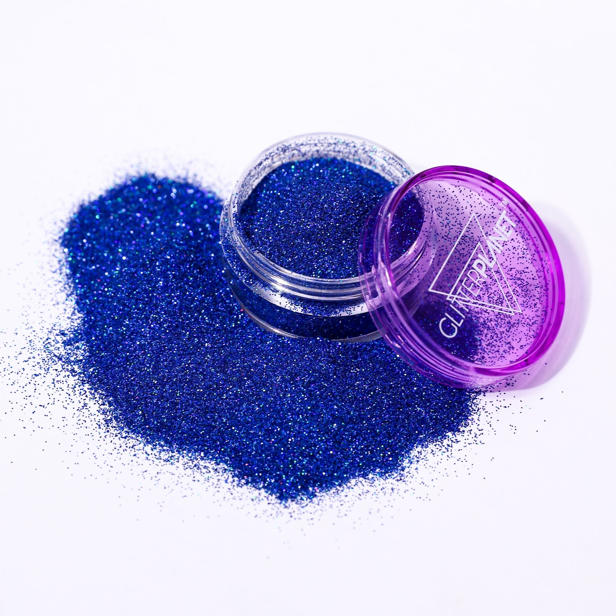 Fine holographic Blue nail glitter in a jar spilled out with the branding Glitter Planet