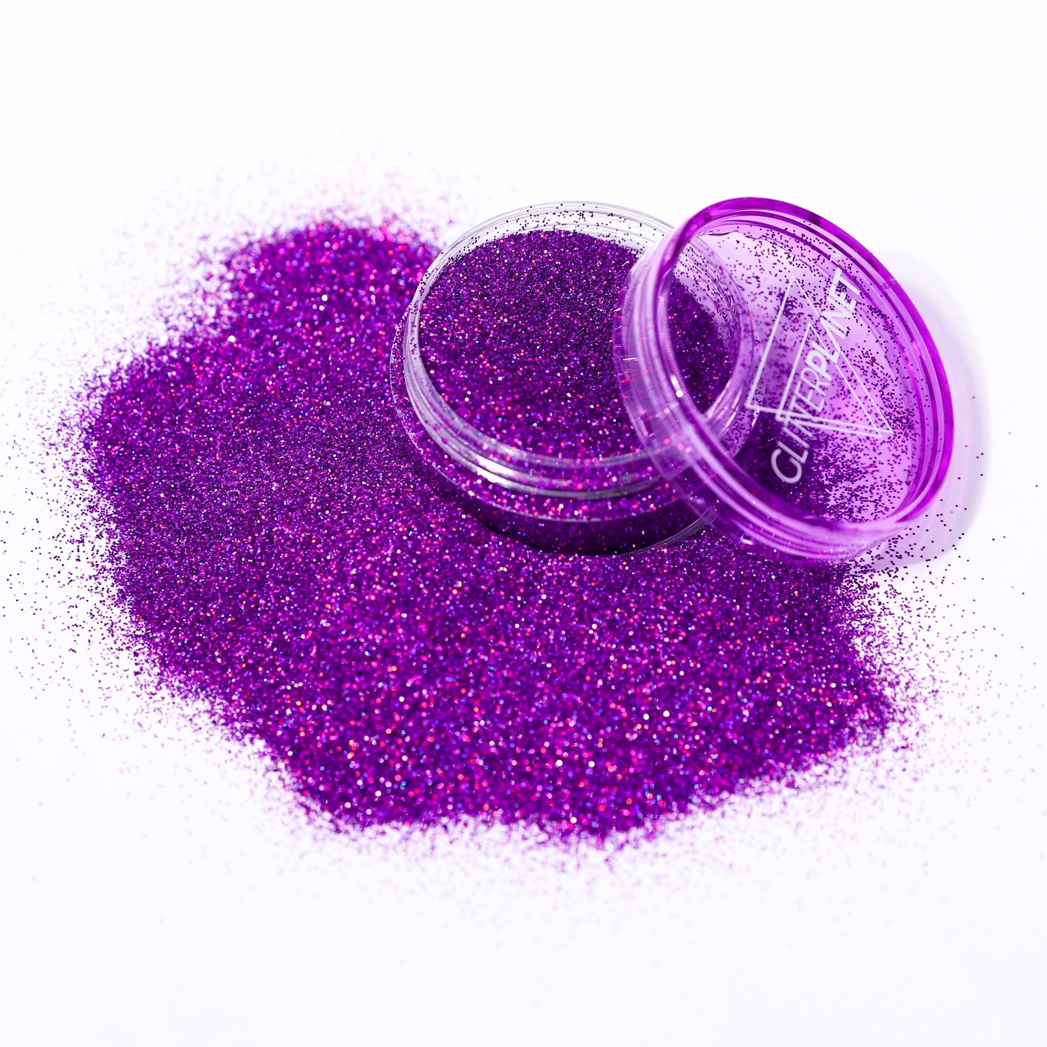 Purple glitter with an open container on a white background