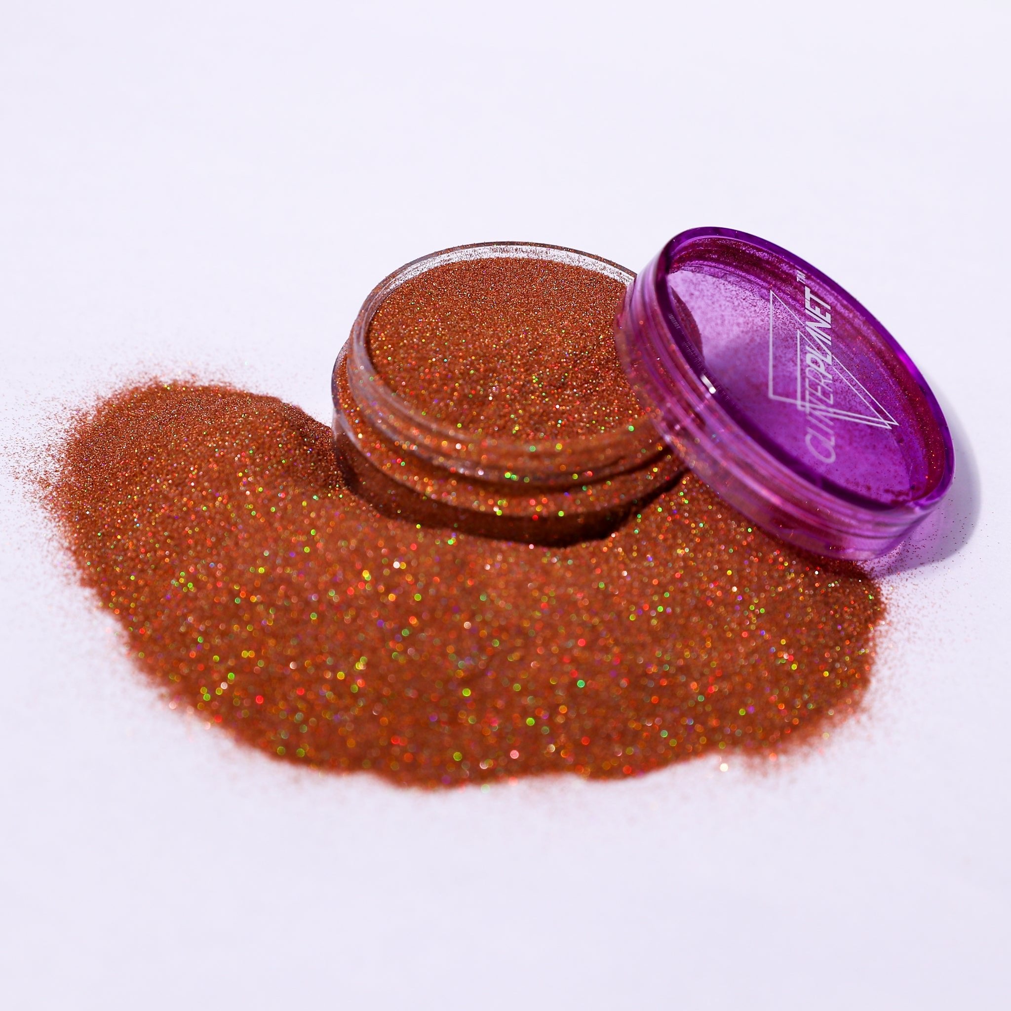 Open container of glitter with a purple lid on a white background