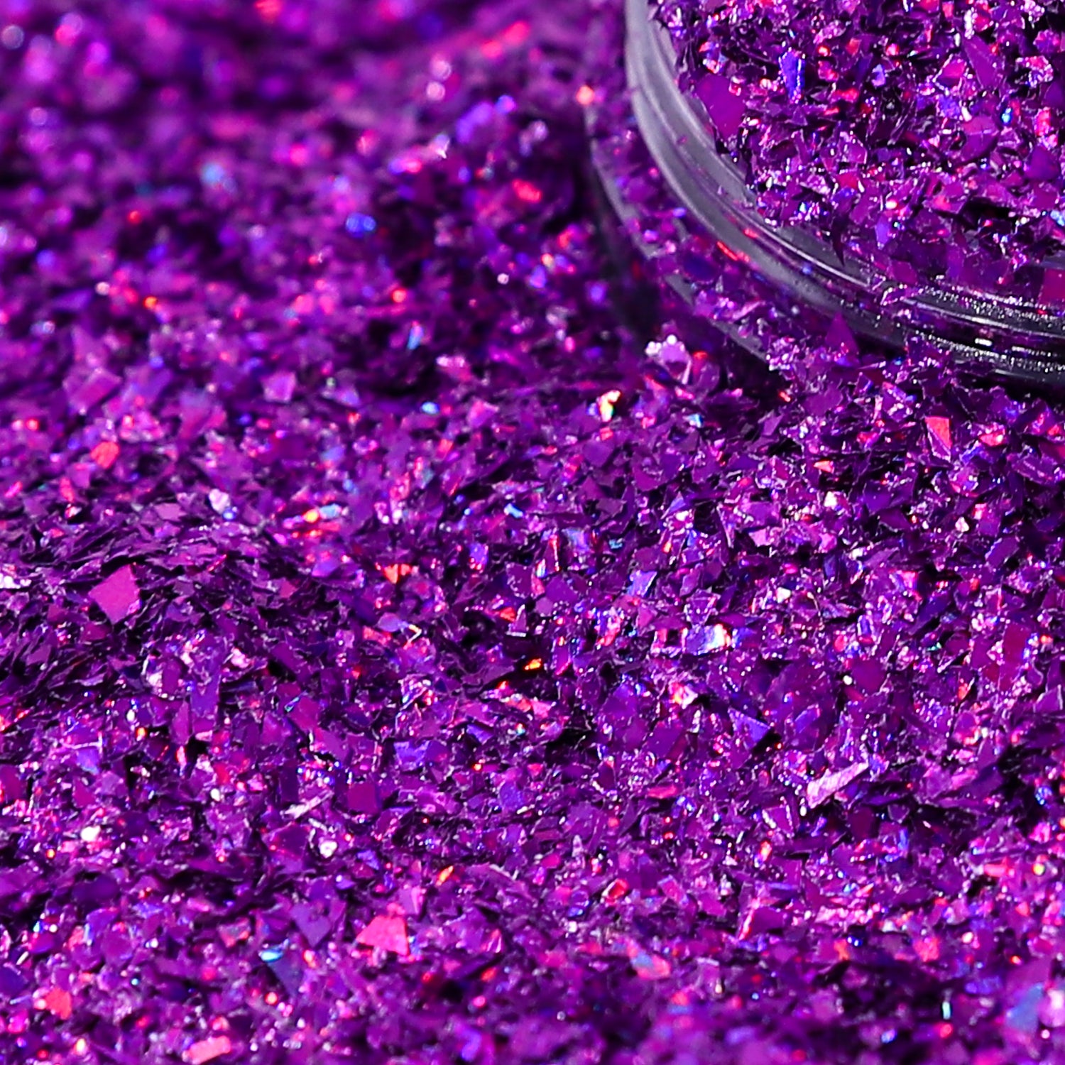 Purple glitter with a clear container partially filled with glitter.