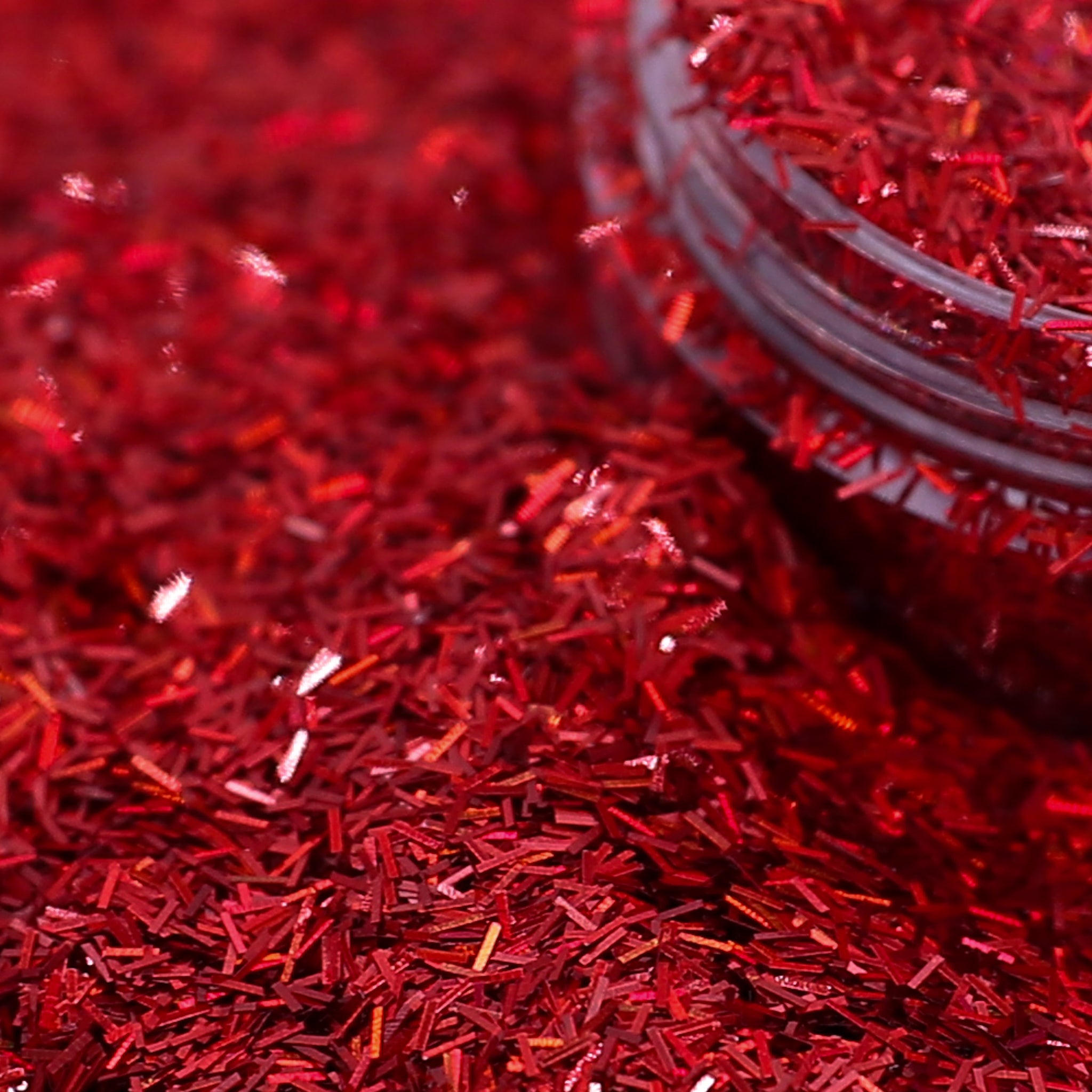 Close-up of red glitter with a container partially visible