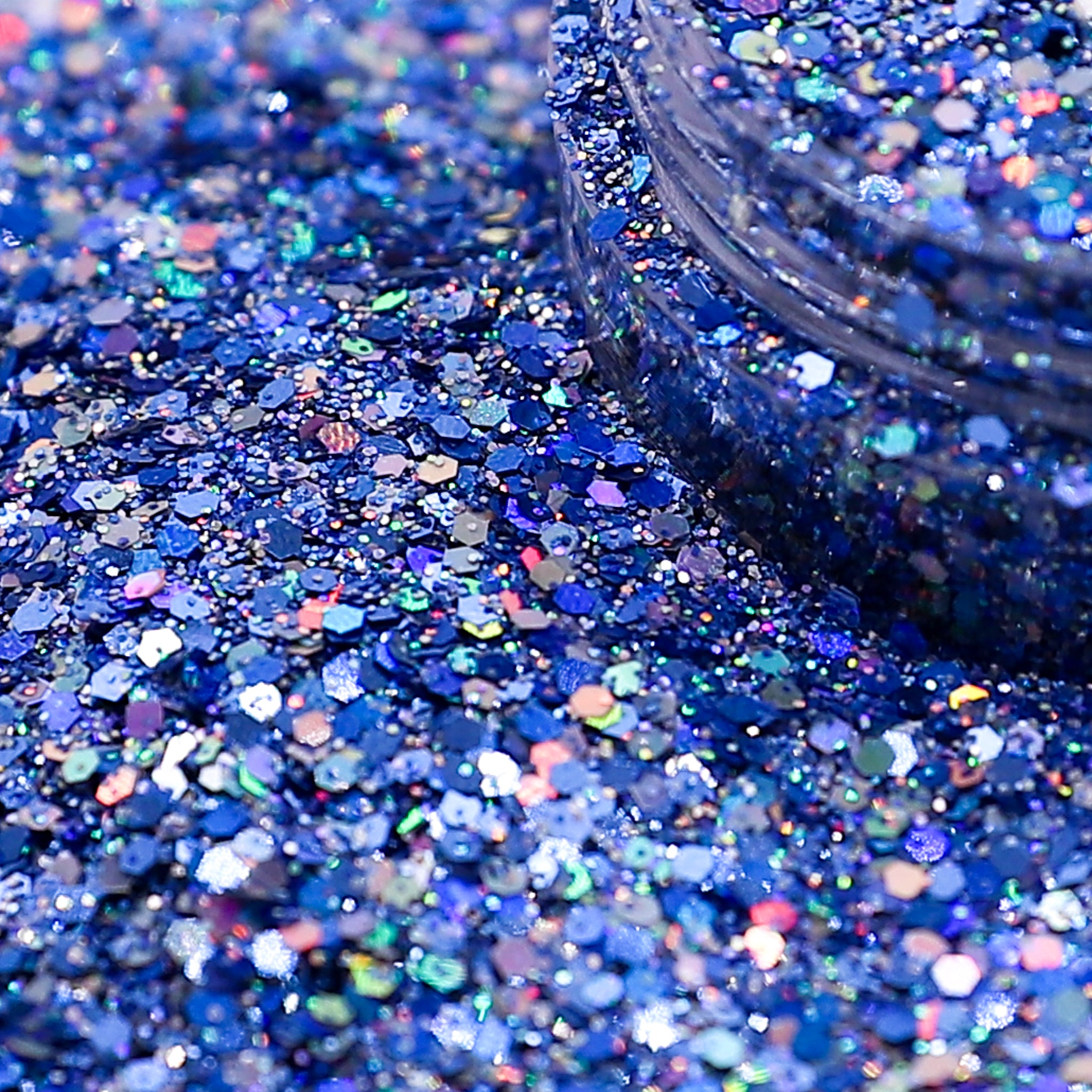 Close-up of blue glitter with a jar partially filled with glitter.
