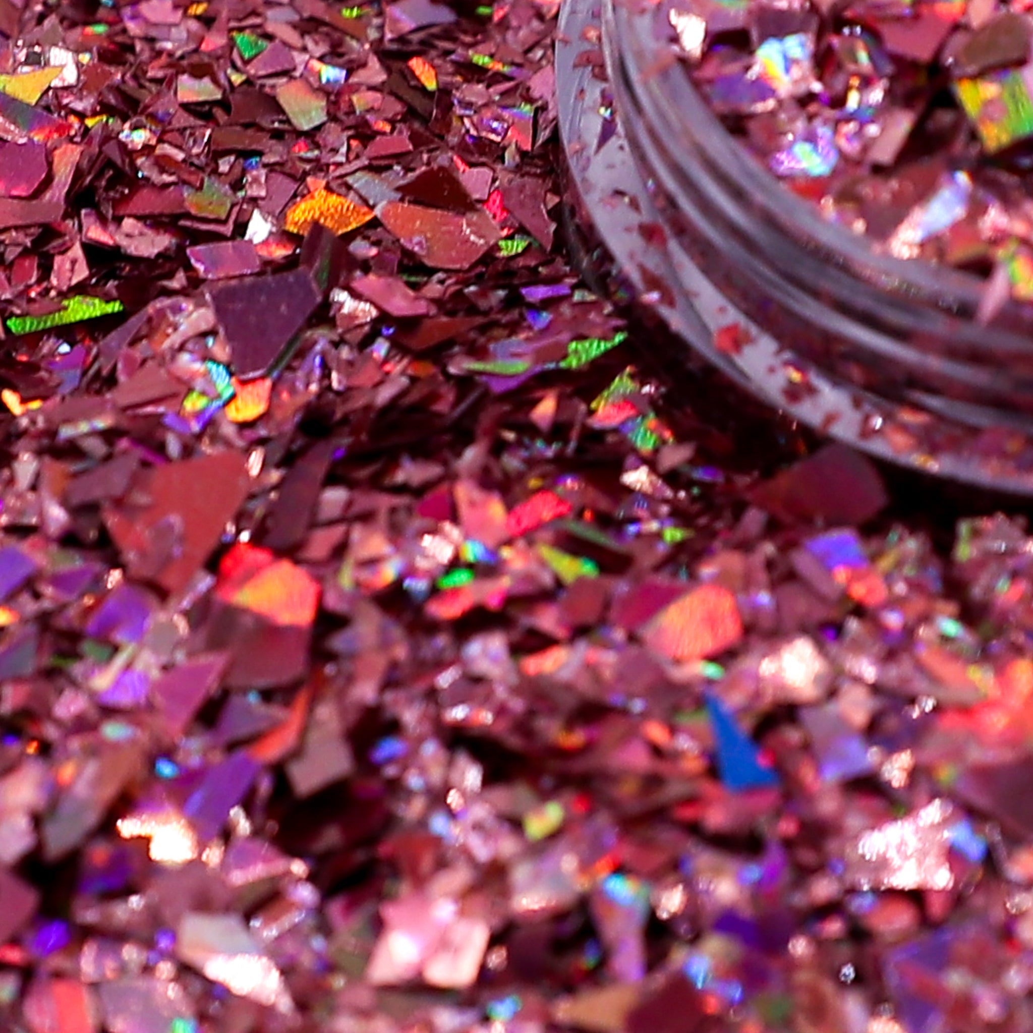 Close-up of pink glitter with a jar of glitter in the background