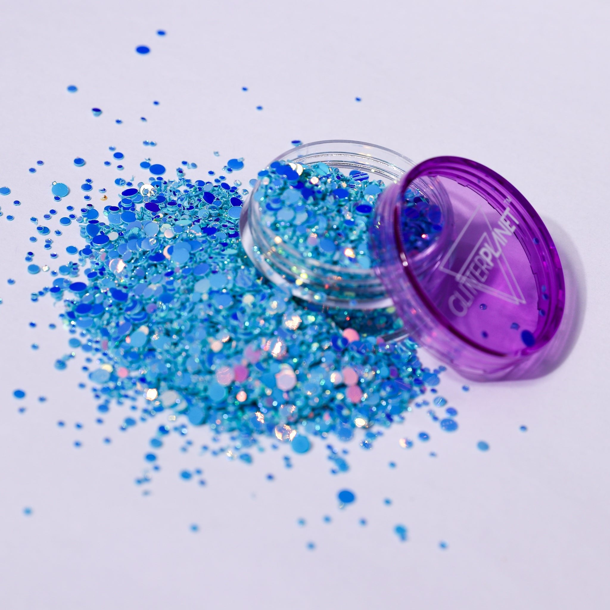 Blue glitter spilling out of a purple container labeled &