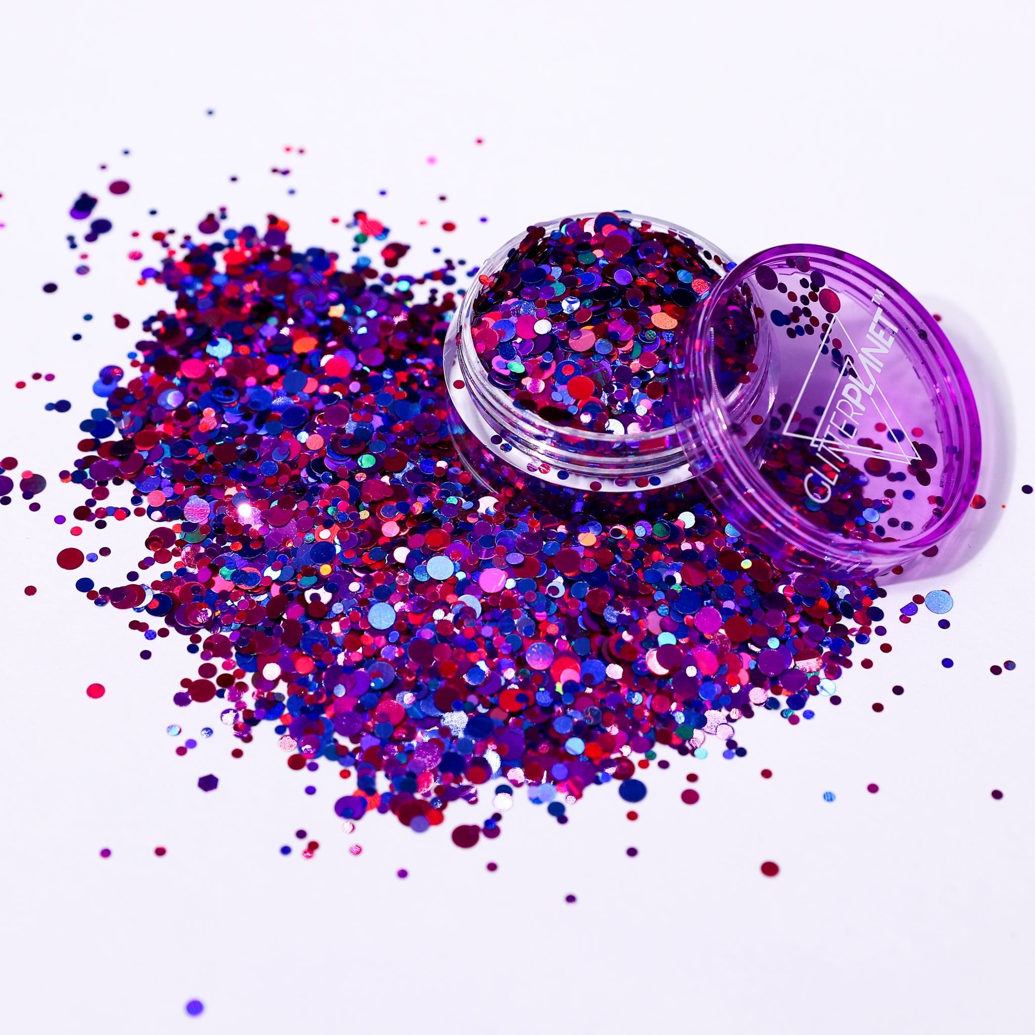 Purple and pink glitter with a open container on a white background