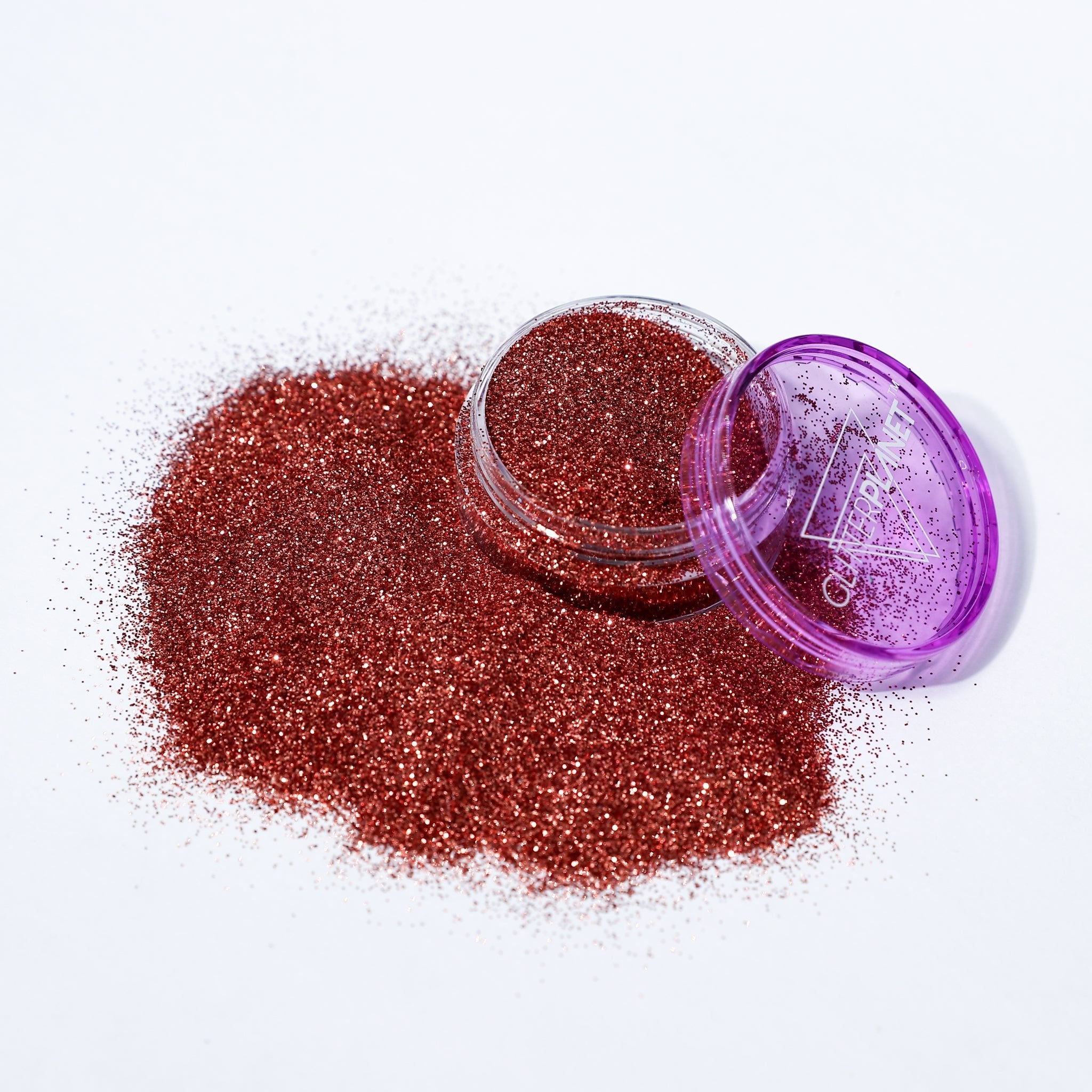 bronze glitter with a purple lid on a white background