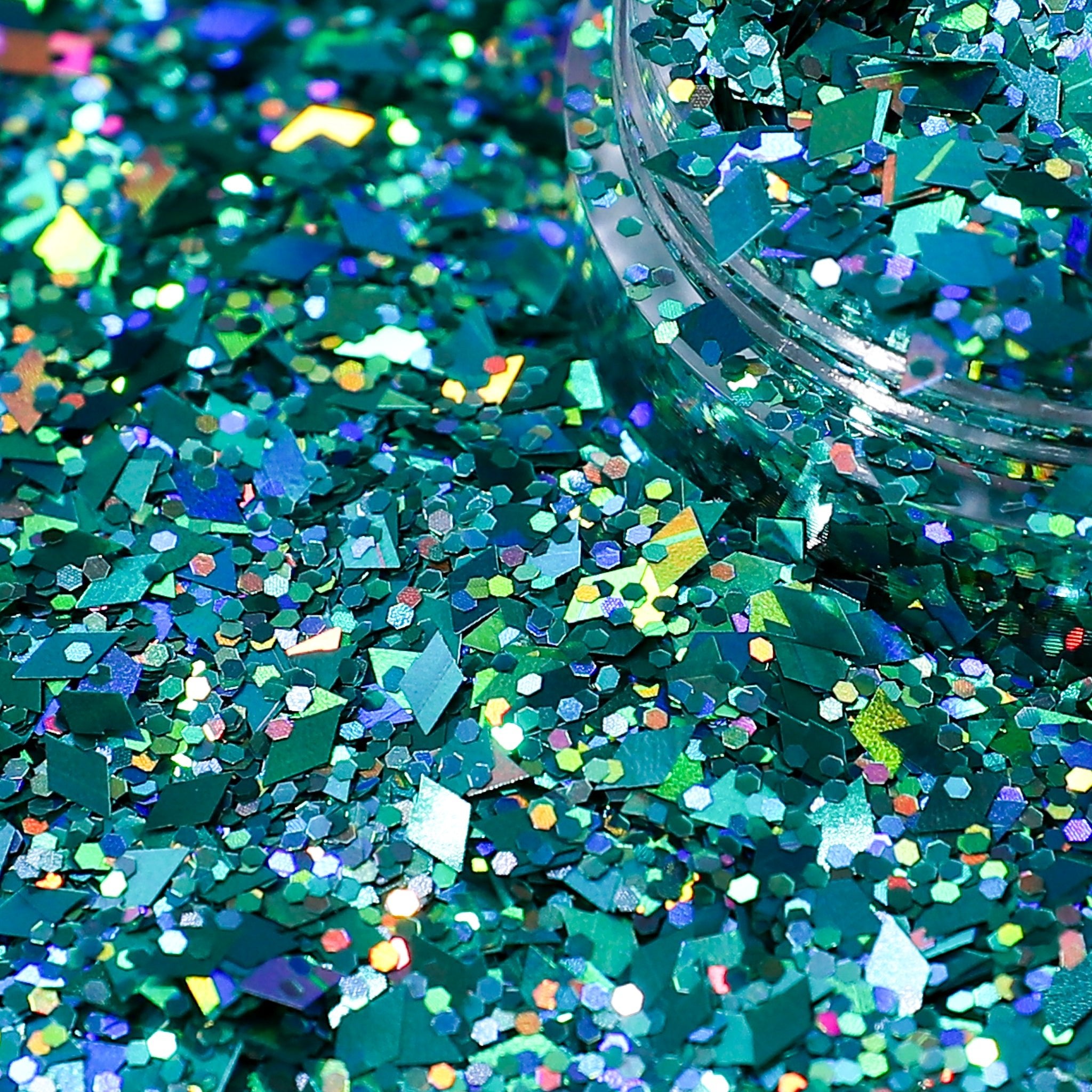 Turquoise glitter with a clear container on a dark background