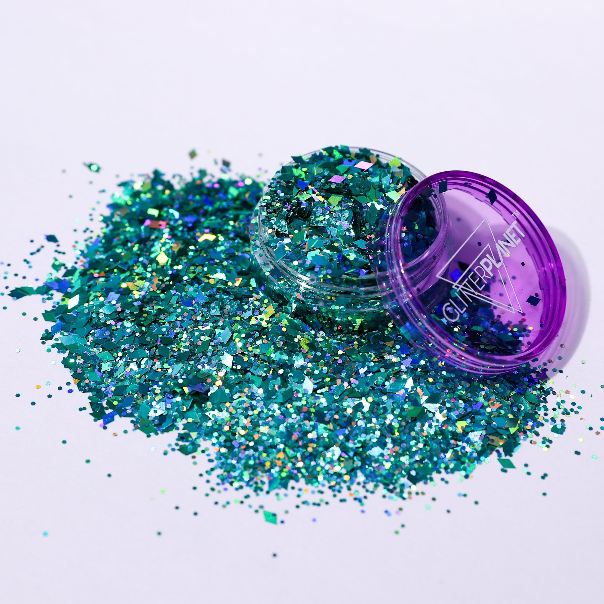 Turquoise glitter spilling out of a purple container labeled &