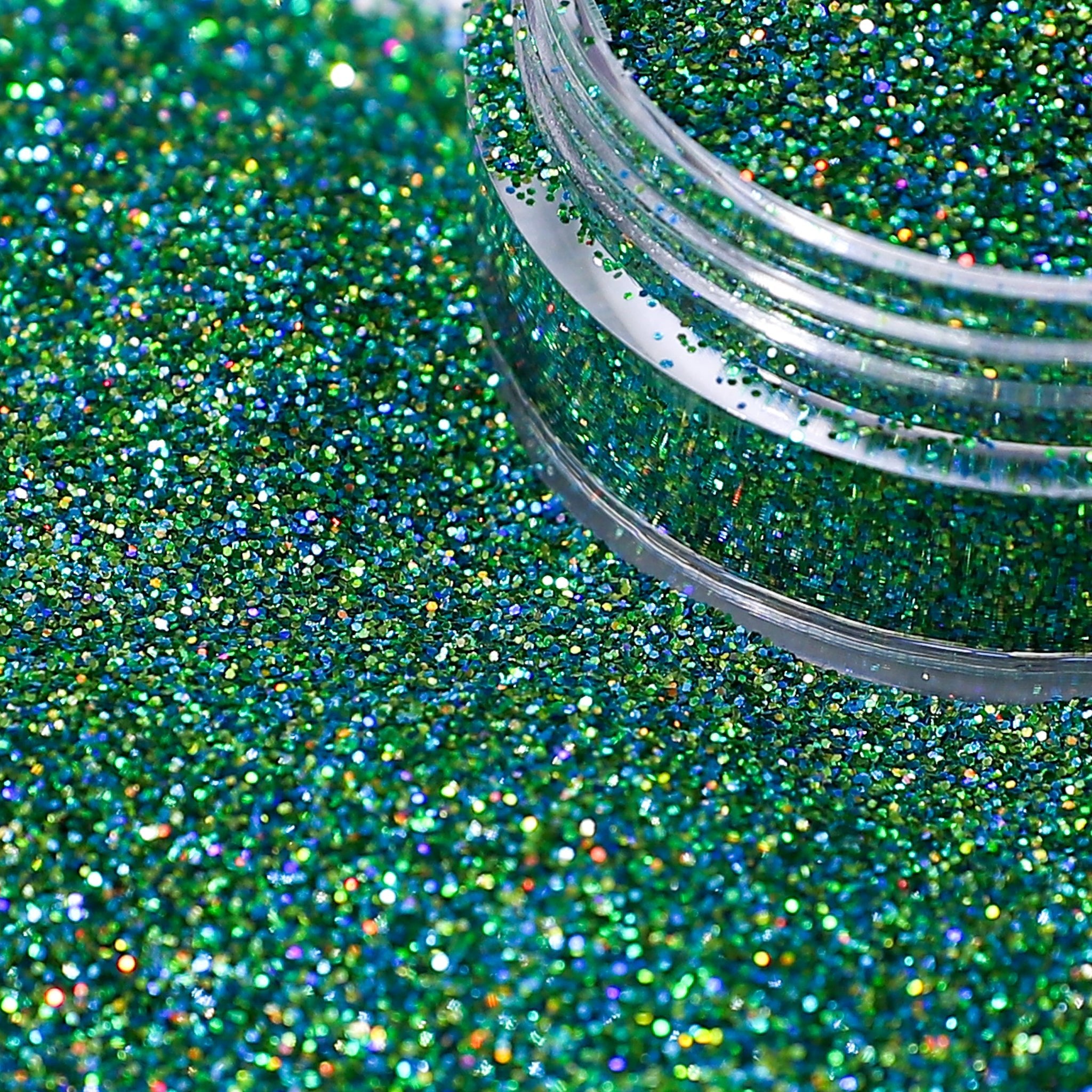 Green glitter with a clear container partially filled with glitter