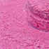 Pink glitter in a clear jar spilled out.