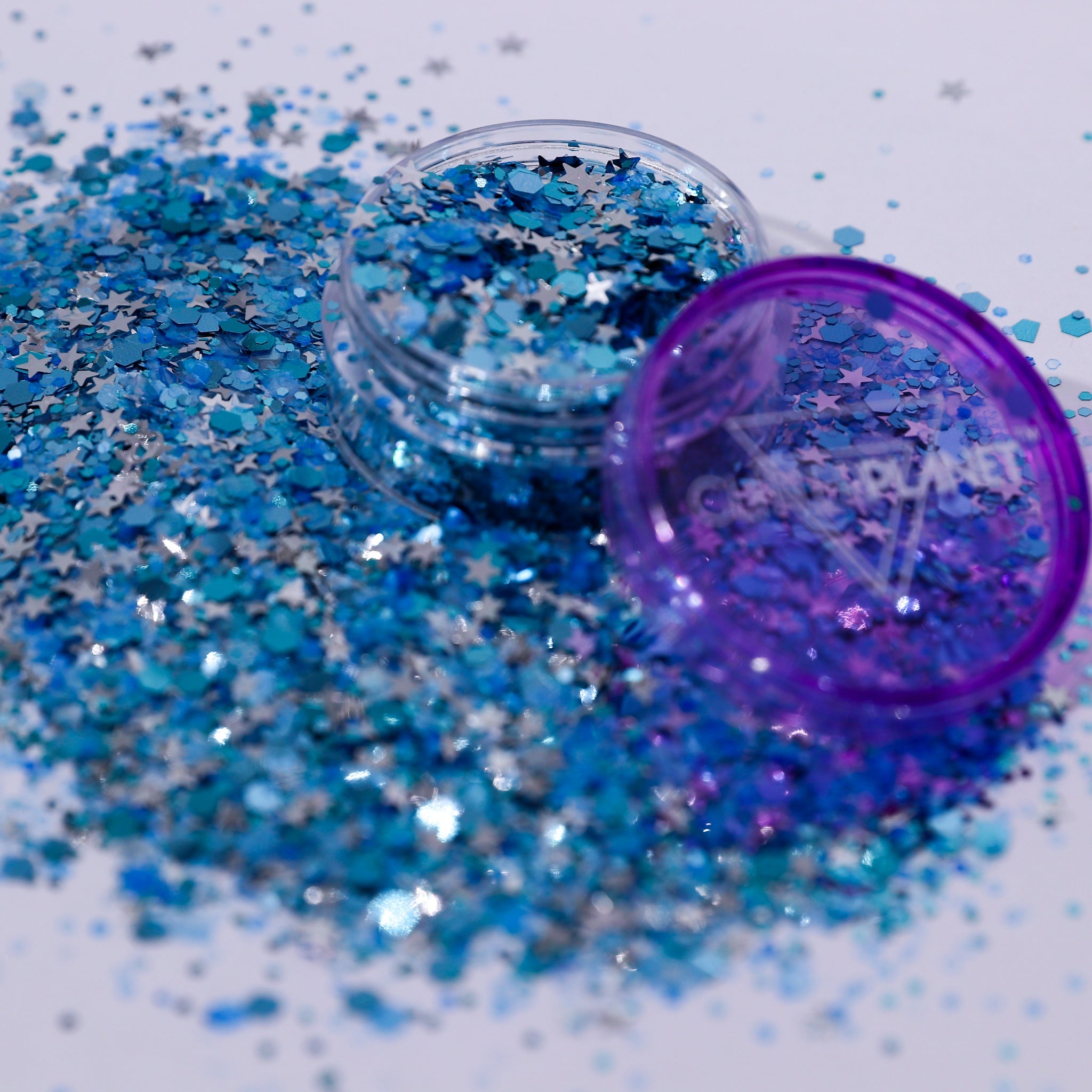 Blue glitter with a purple container on a white background