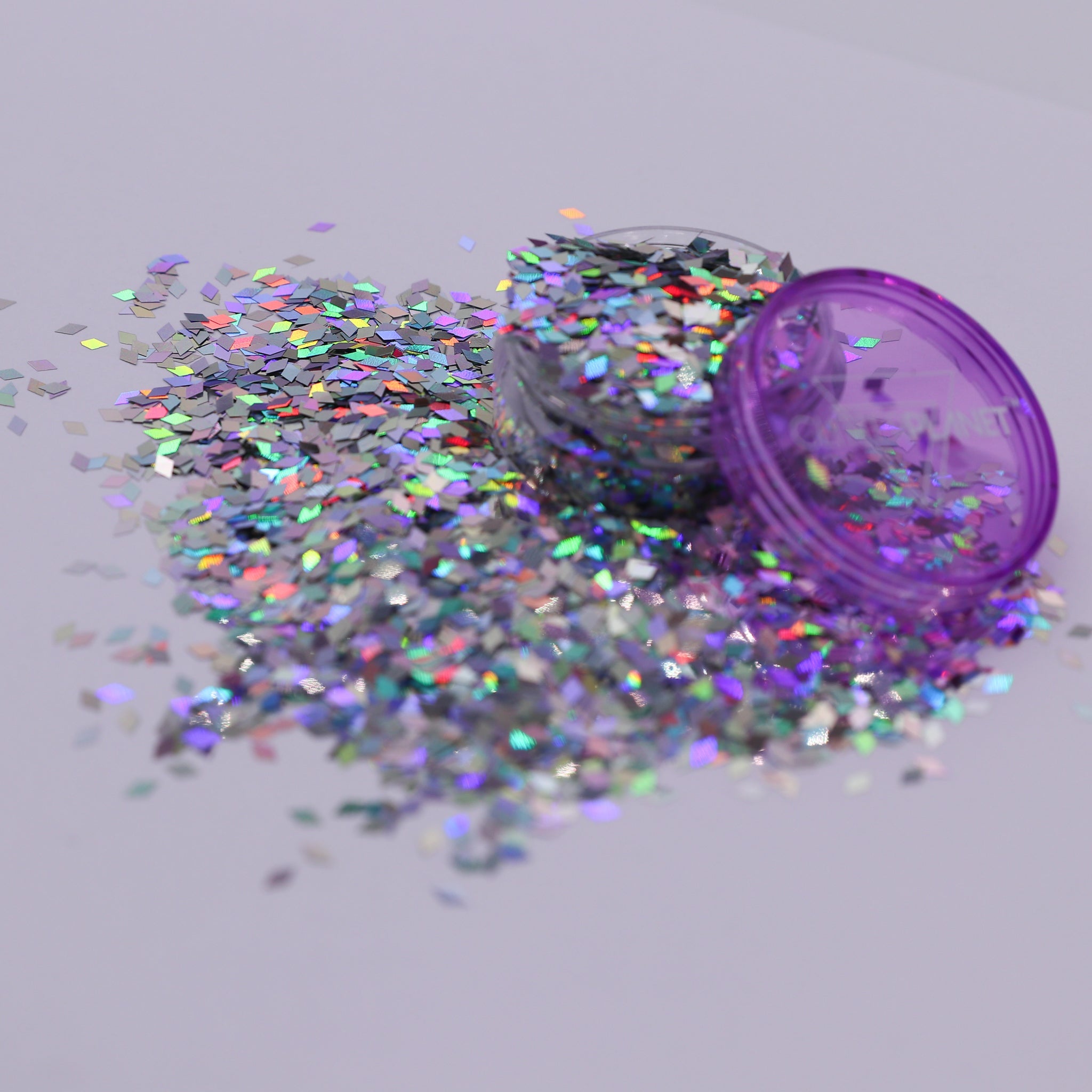 Jar of glitter with scattered holo diamonds on a light gray background