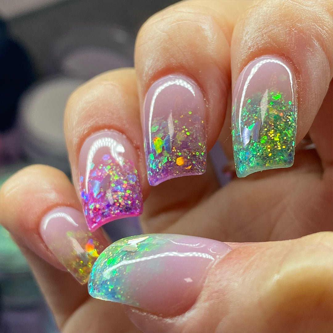 short square glittery nails with rainbow colours on the nail tips