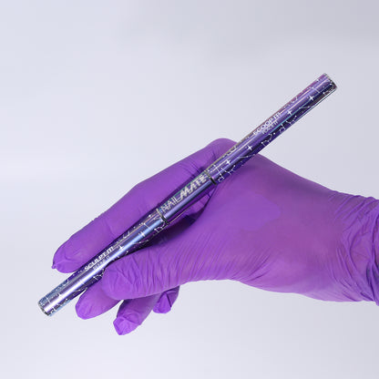 A hand wearing a purple nitrile glove holds a metallic purple and silver nail mate polygel brush against a plain light gray background.