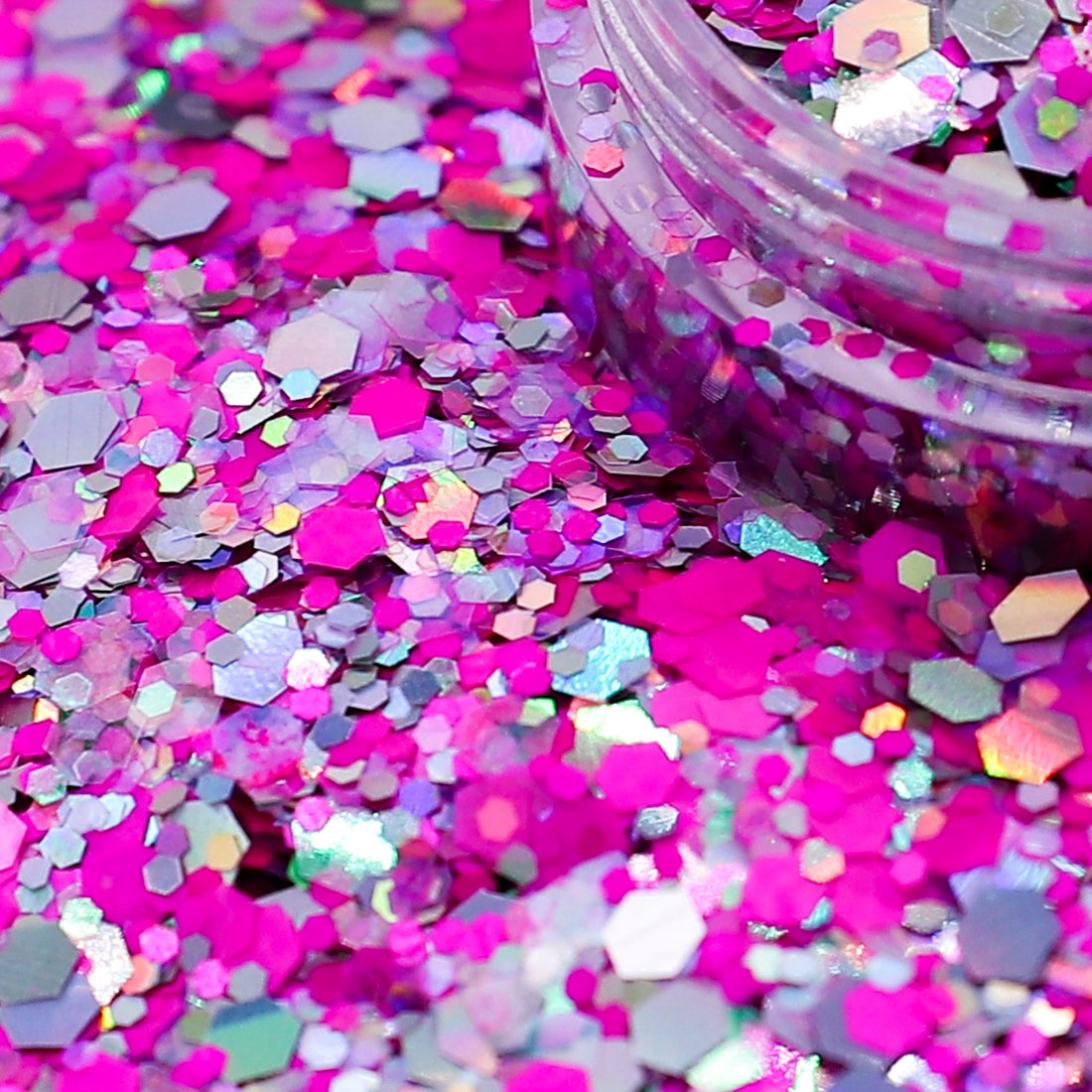 Colorful glitter with a clear container on a pink background