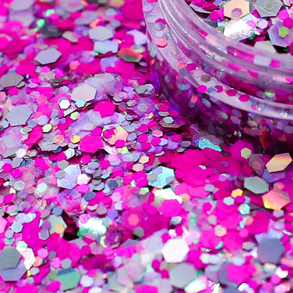 Colorful glitter with a clear container on a pink background