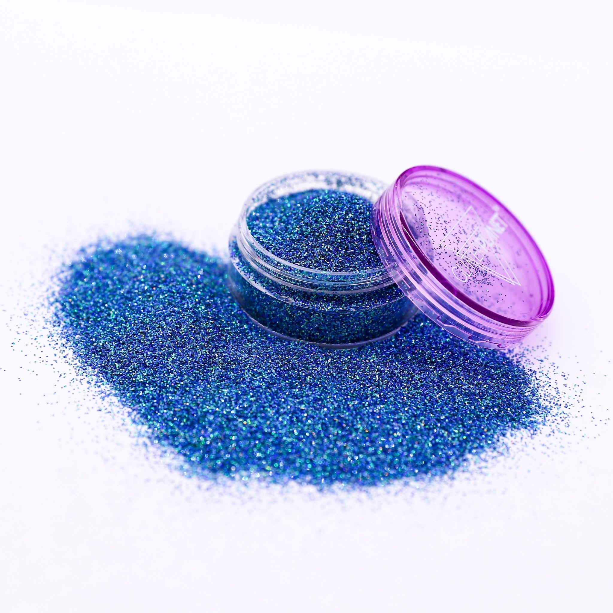 Blue glitter in an open container with a purple lid on a white background