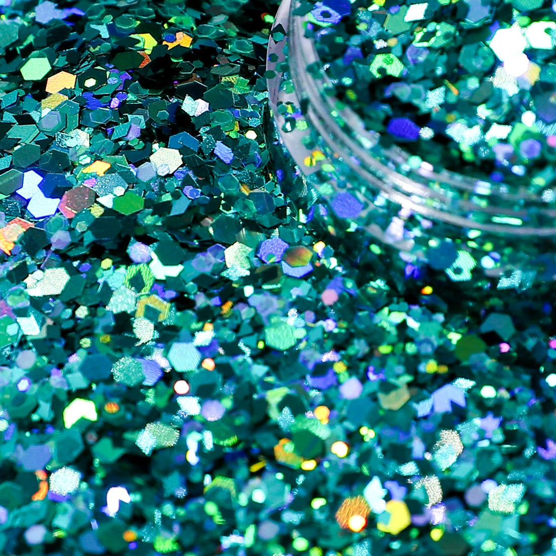 Close-up of teal glitter with a jar of glitter in the background
