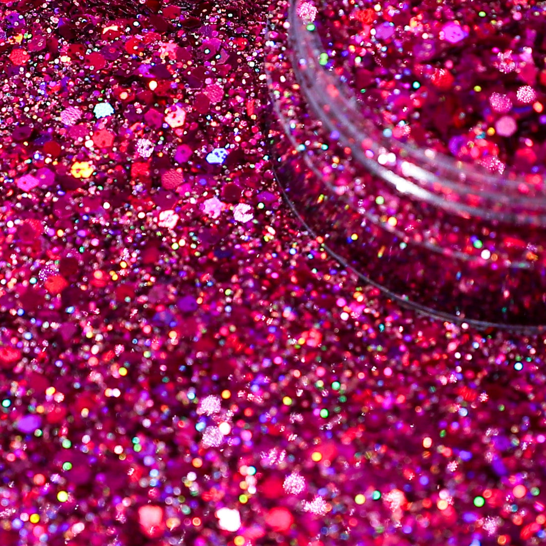 Close-up of pink glitter with a clear container partially filled with glitter.