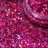 Close-up of pink glitter with a clear container partially filled with glitter.