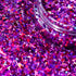 Close-up of pink and purple glitter with a jar partially filled with glitter.