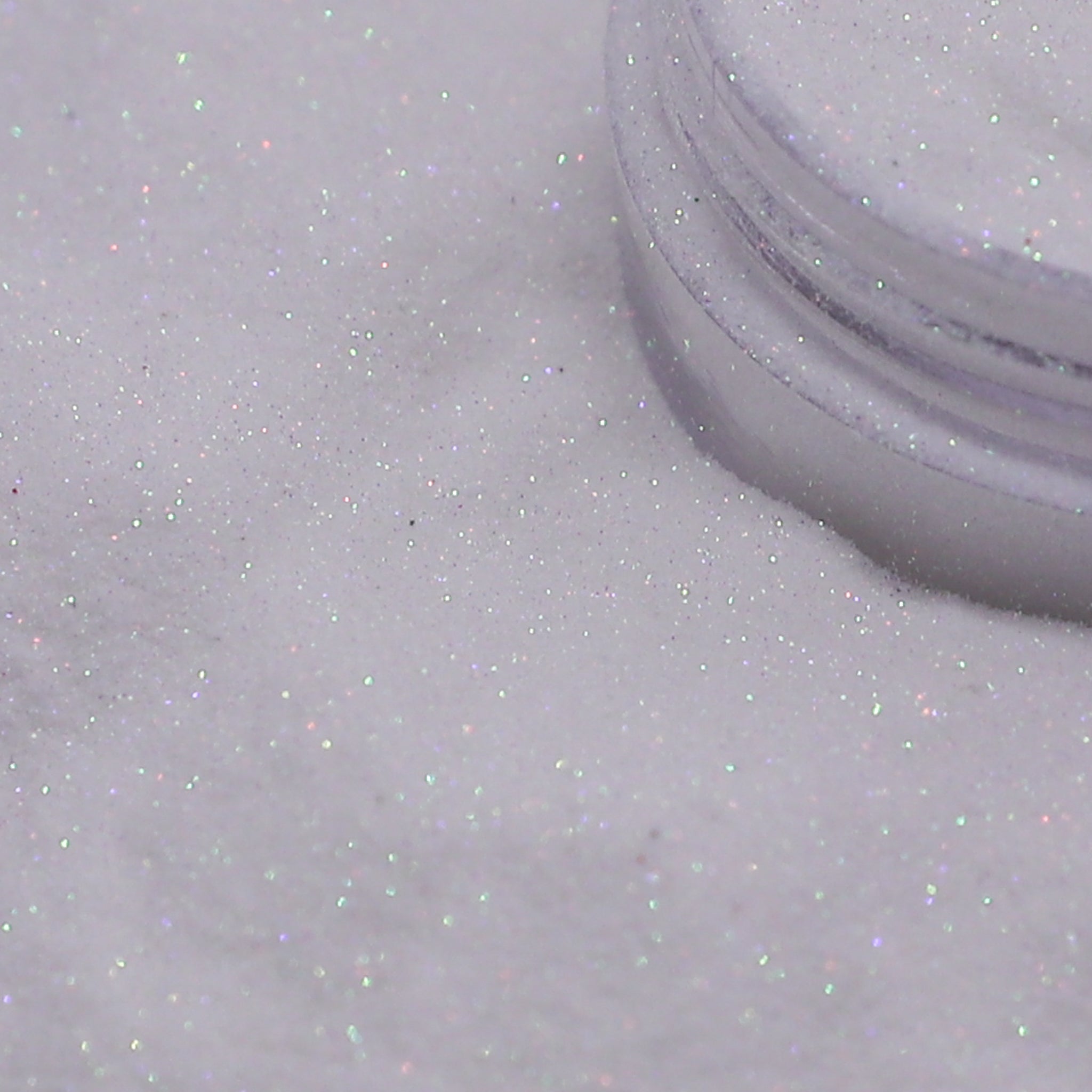 Close-up of a container of white glitter on a light gray background