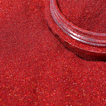 Close-up of red glittery powder with a clear container on a red background