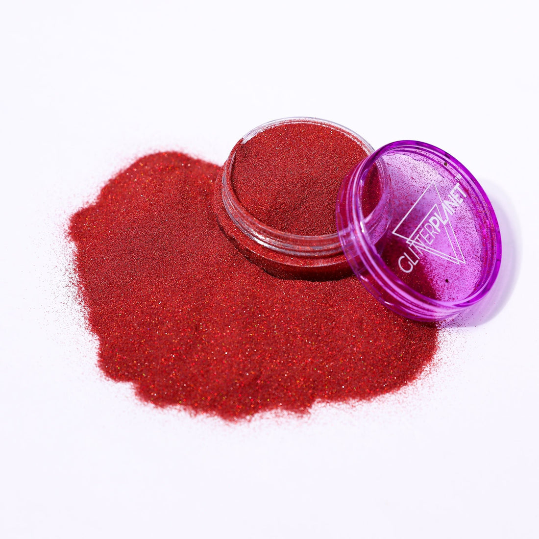 Red glitter powder spilling out of a purple container labeled &
