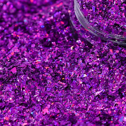 Purple glitter with a clear container partially filled with glitter.
