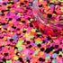 Colorful glitter with a clear container on a multicolored glitter background