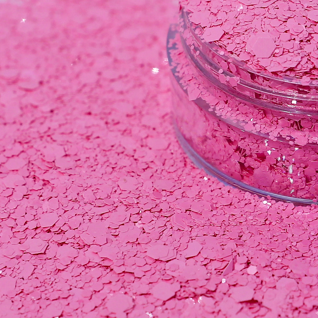 Pink glitter in a clear jar spilled out.