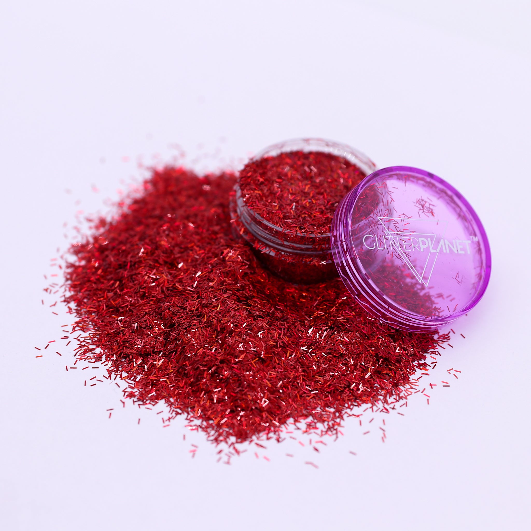 Red glitter with a purple lid on a white background