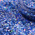 Close-up of blue glitter with a jar partially filled with glitter.