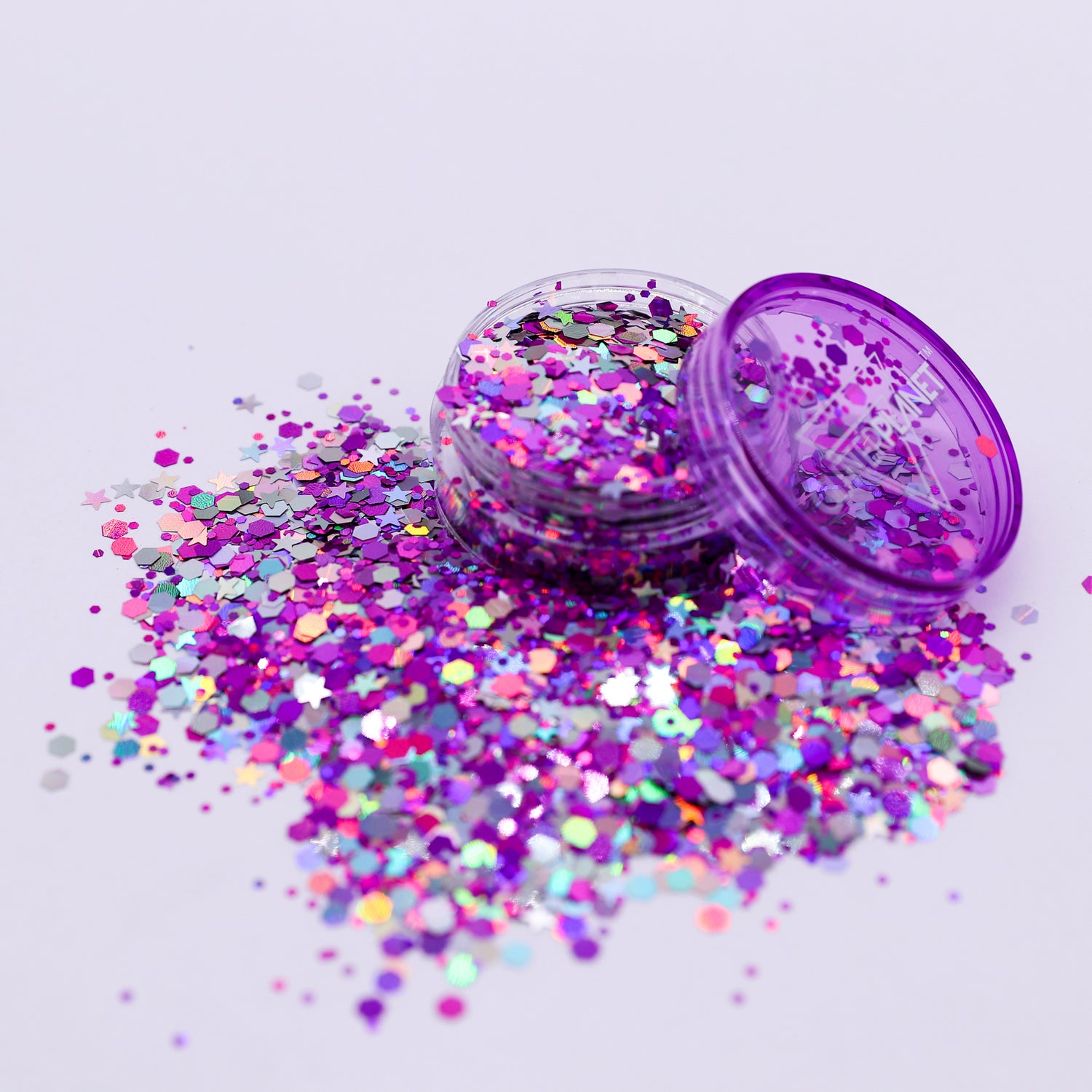 Purple glitter container with scattered glitter on a light purple background