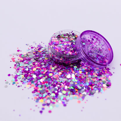 Purple glitter container with scattered glitter on a light purple background