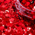 Red glitter with a clear container partially filled with glitter