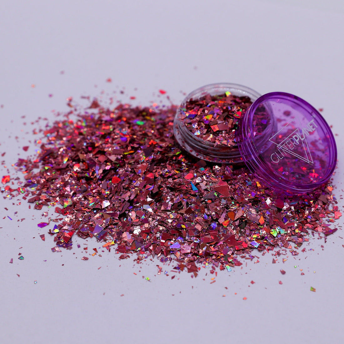 rose glitter with open container on a light gray background