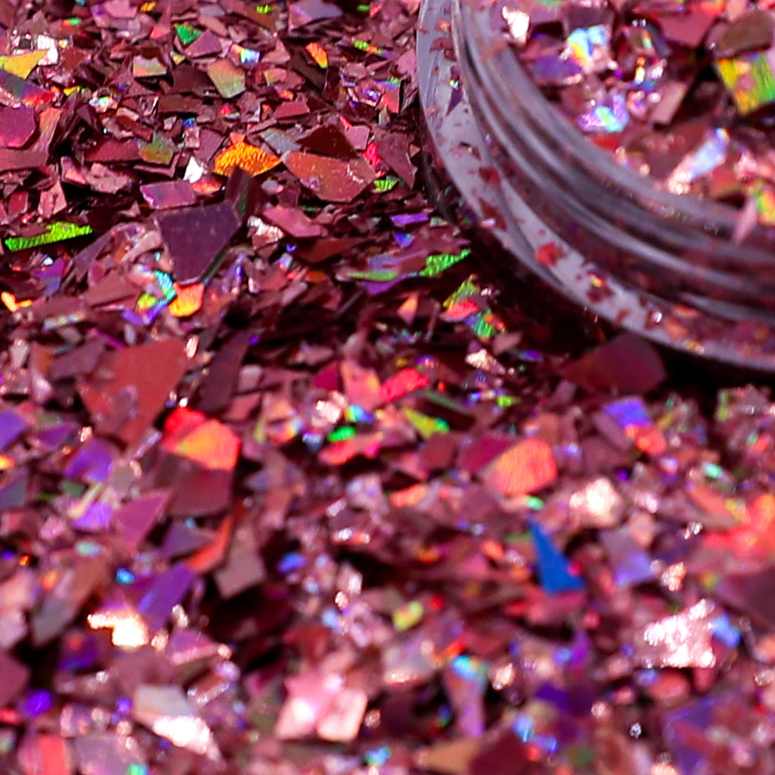 Close-up of pink glitter with a jar of glitter in the background