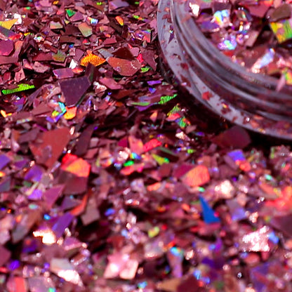 Close-up of pink glitter with a jar of glitter in the background
