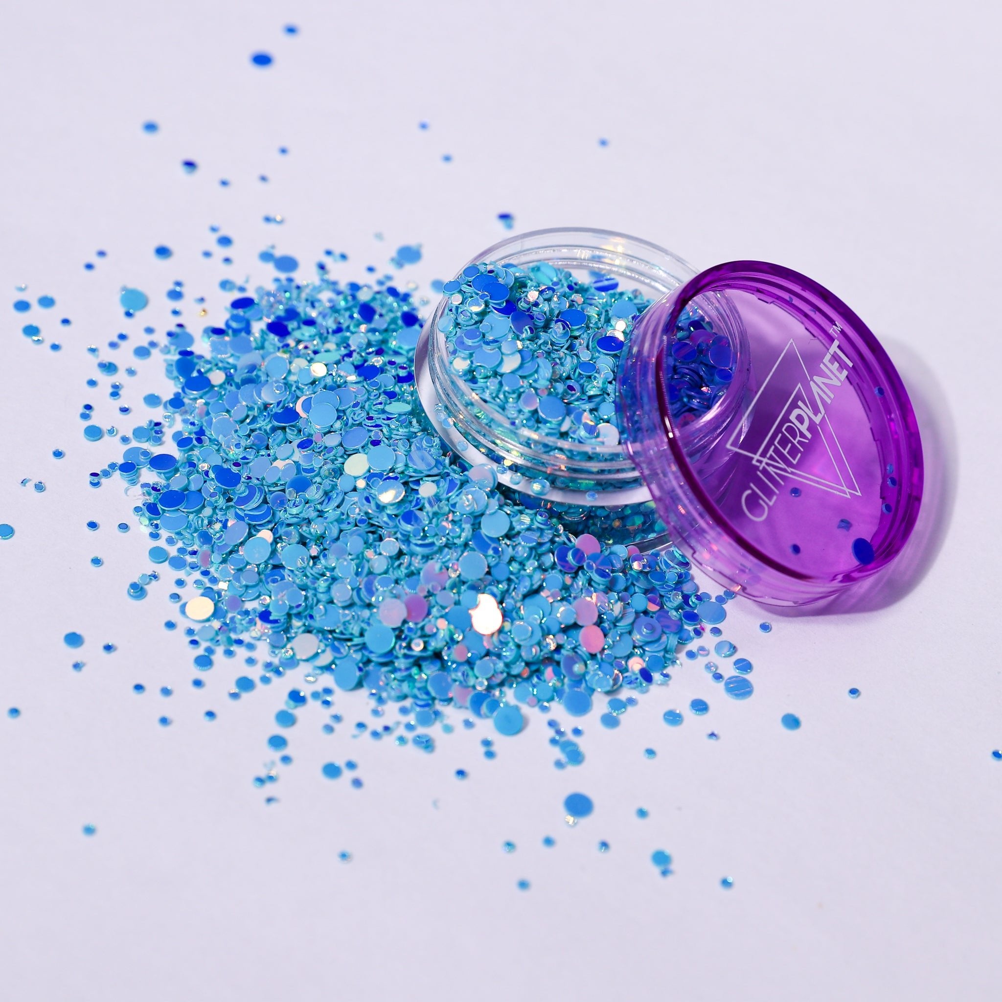 Blue glitter spilling out of a purple container labeled &