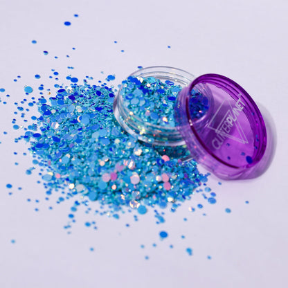 Blue glitter spilling out of a purple container labeled &