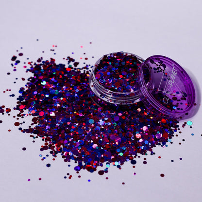 Purple glitter container with scattered glitter on a light purple background