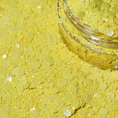 Yellow glitter in a clear jar on a yellow background