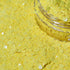 Yellow glitter in a clear jar on a yellow background