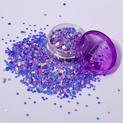 Purple glitter jar with scattered glitter on a light purple background