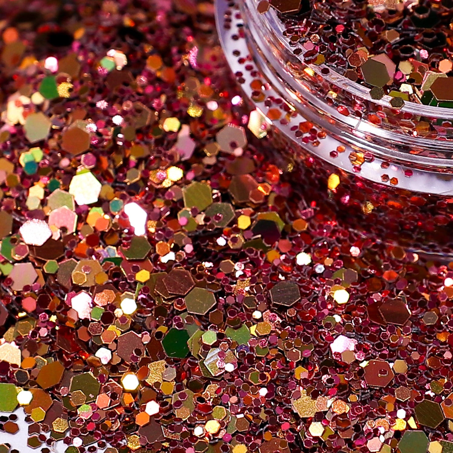 Close-up of rose gold glitter with a clear container partially filled with glitter.