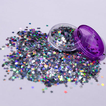 Star-shaped glitter spilling out of a purple container on a light gray background