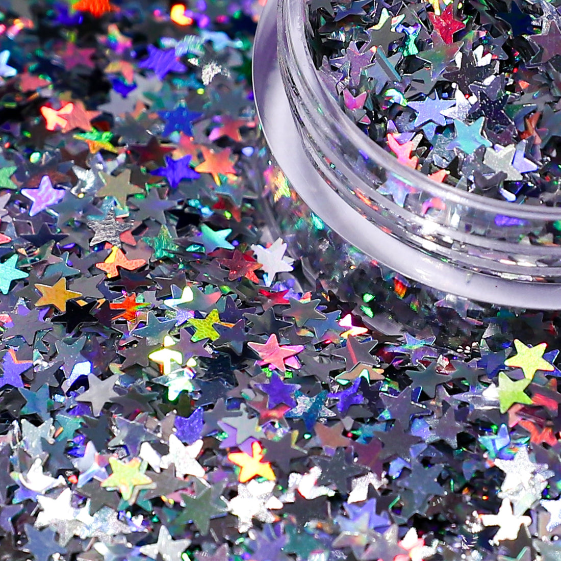 Colorful star-shaped glitter scattered on a black background with a container of glitter.