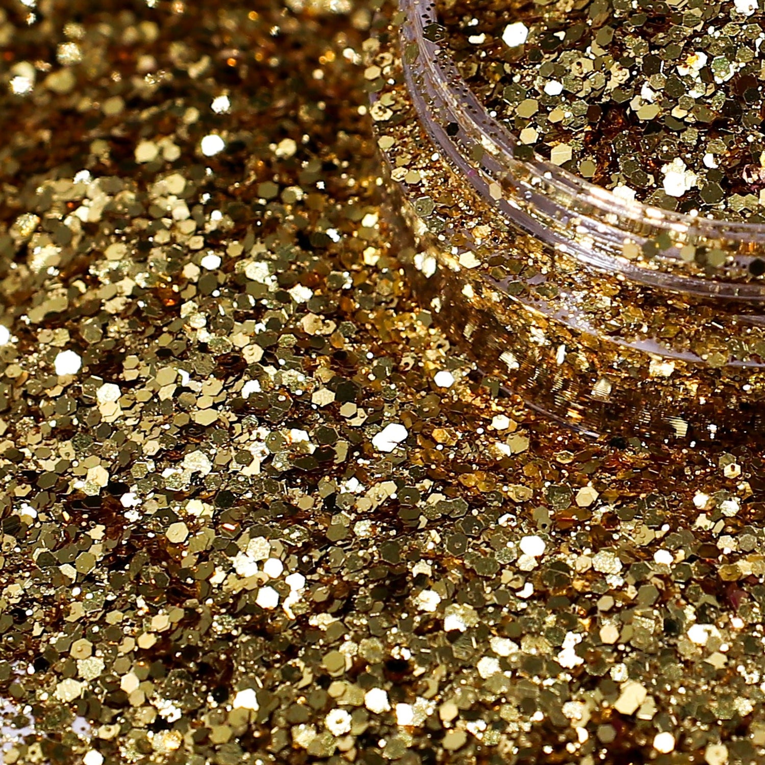 Close-up of gold glitter with a jar lid in the background